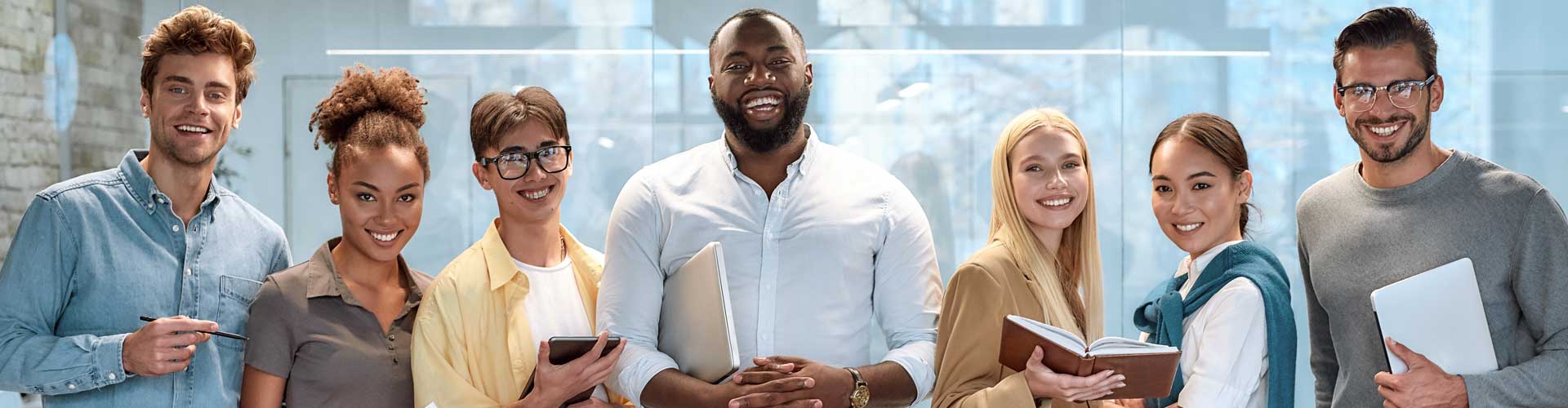 smiling group of diverse employees in a modern office setting